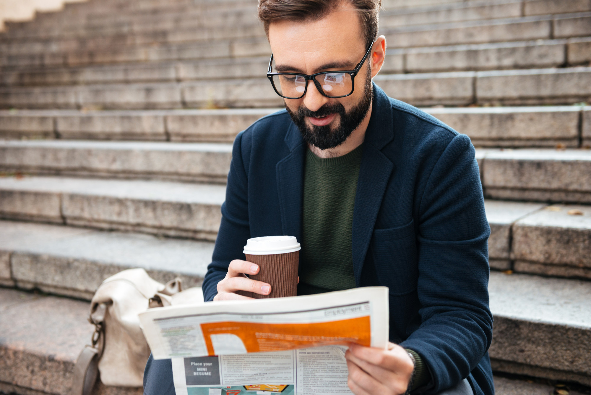 Jeune homme en train de chercher de l'information dans un journal pour alimenter son organisme de formation certifié qualiopi
